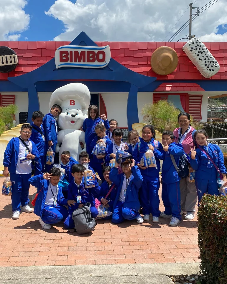 Grupo de estudiantes y acompañantes en la visita a Bimbo